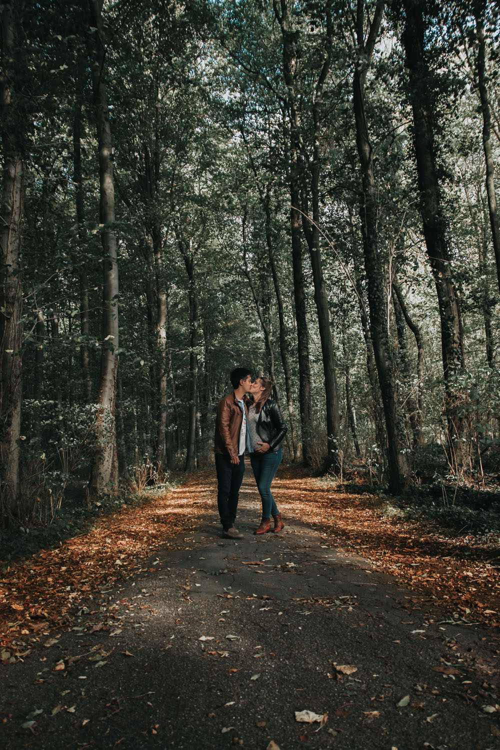un couple s'embrasse dans la foret en automne en belgique halle