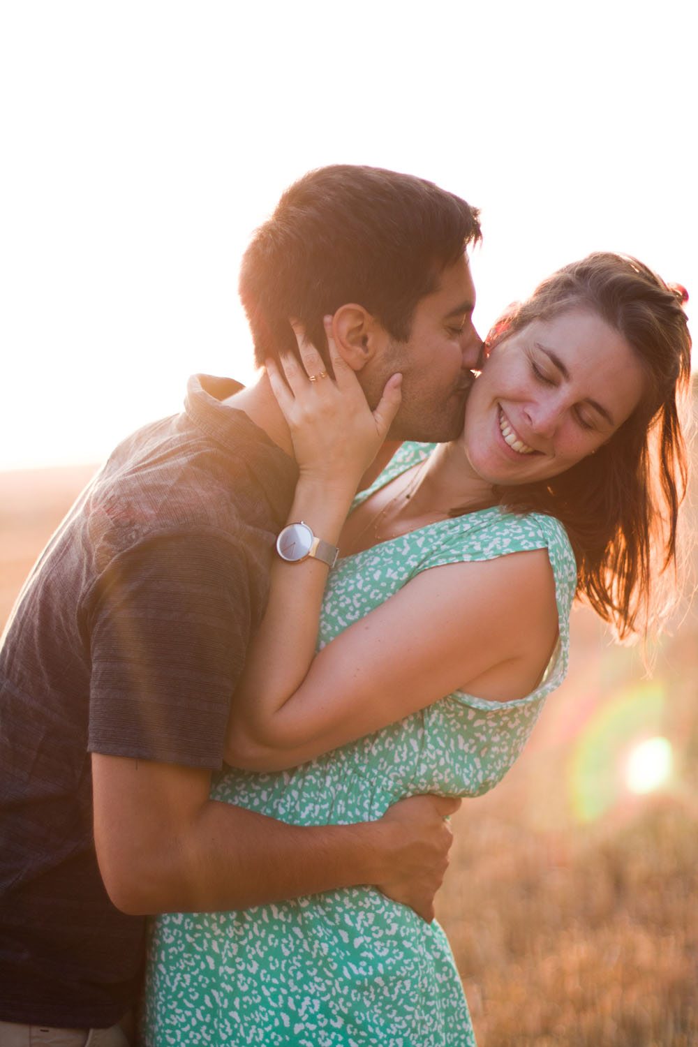 Un couple s'embrasse dans un champ de clé au coucher du soleil shooting photo couple belgique