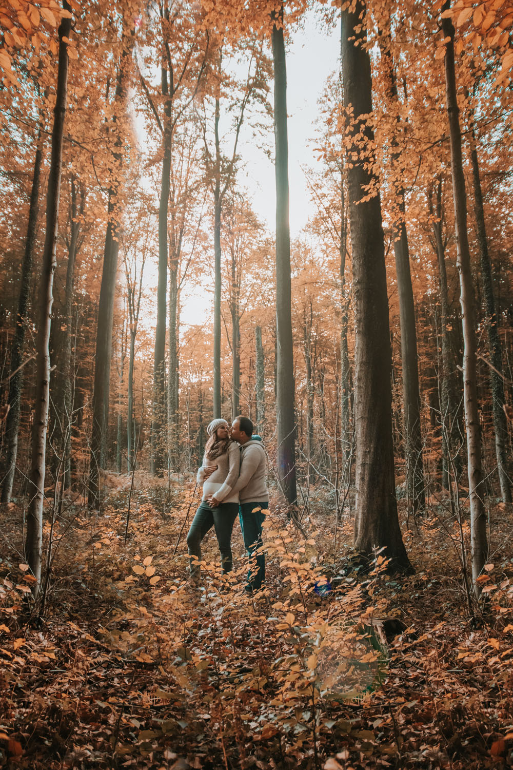 Shooting photo de couple dans les bois en automne avec femme enceinte en Belgique Walonnie