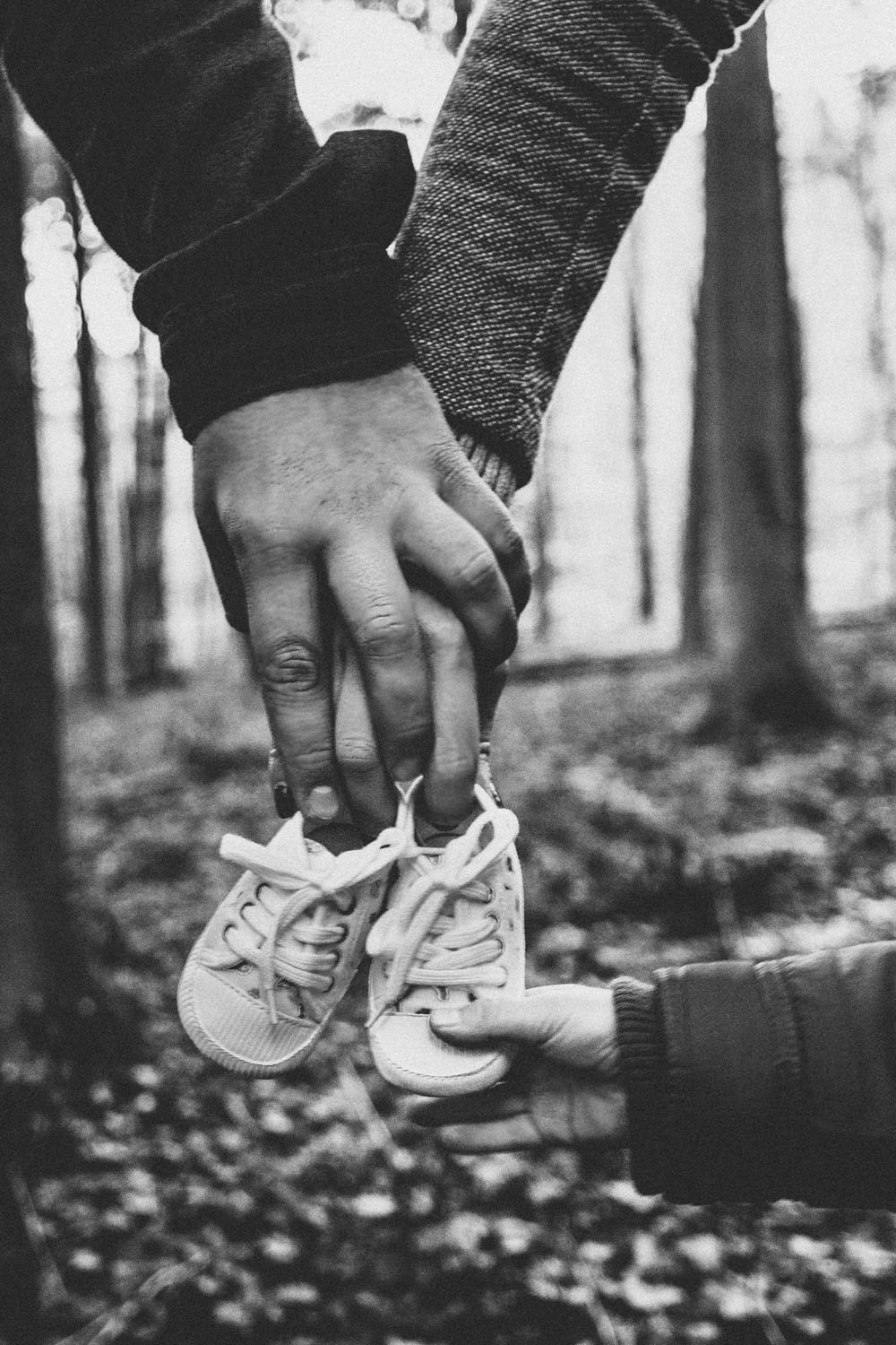 Photo grossesse parents qui tiennent des chaussures de bebe avec mains enfants